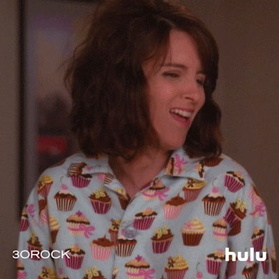 Tina Fey laughs sarcastically in cupcake pyjamas.
