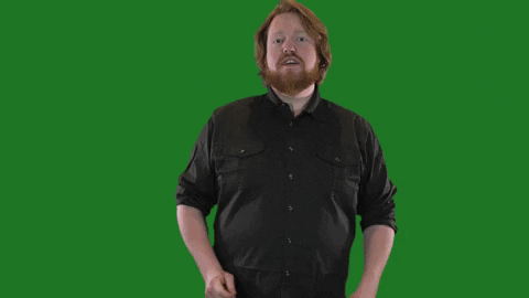 A man wearing a black sweater pretends to play the drums as the words, "Ba dum tss," appear below him.