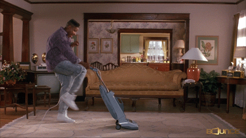 A man vacuums energetically.