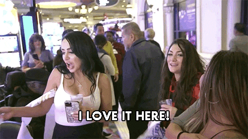 A young woman with dark hair shouts, "I love it here!"
